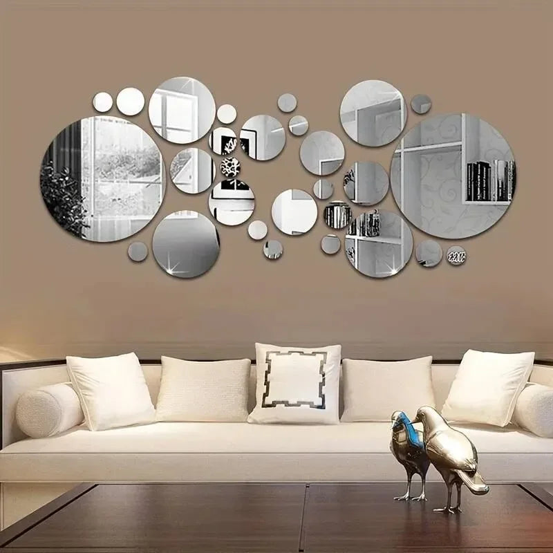 Modern living room with beige sofa, decorative white cushions, circular wall mirrors, and metal bird sculptures on wooden table