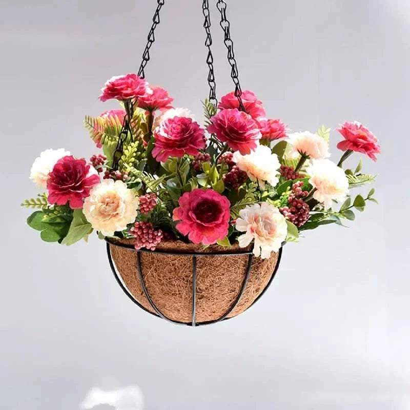 Hanging basket with artificial pink and white flowers, green leaves, and decorative berries in a wire and coir planter