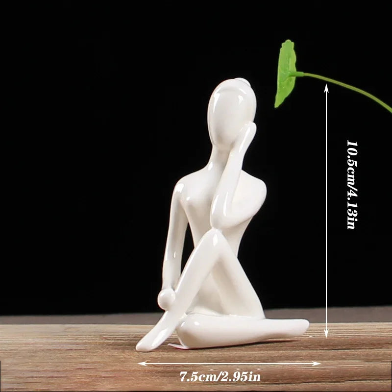 Minimalist white ceramic abstract human figure sculpture sitting, modern home decor on wooden surface