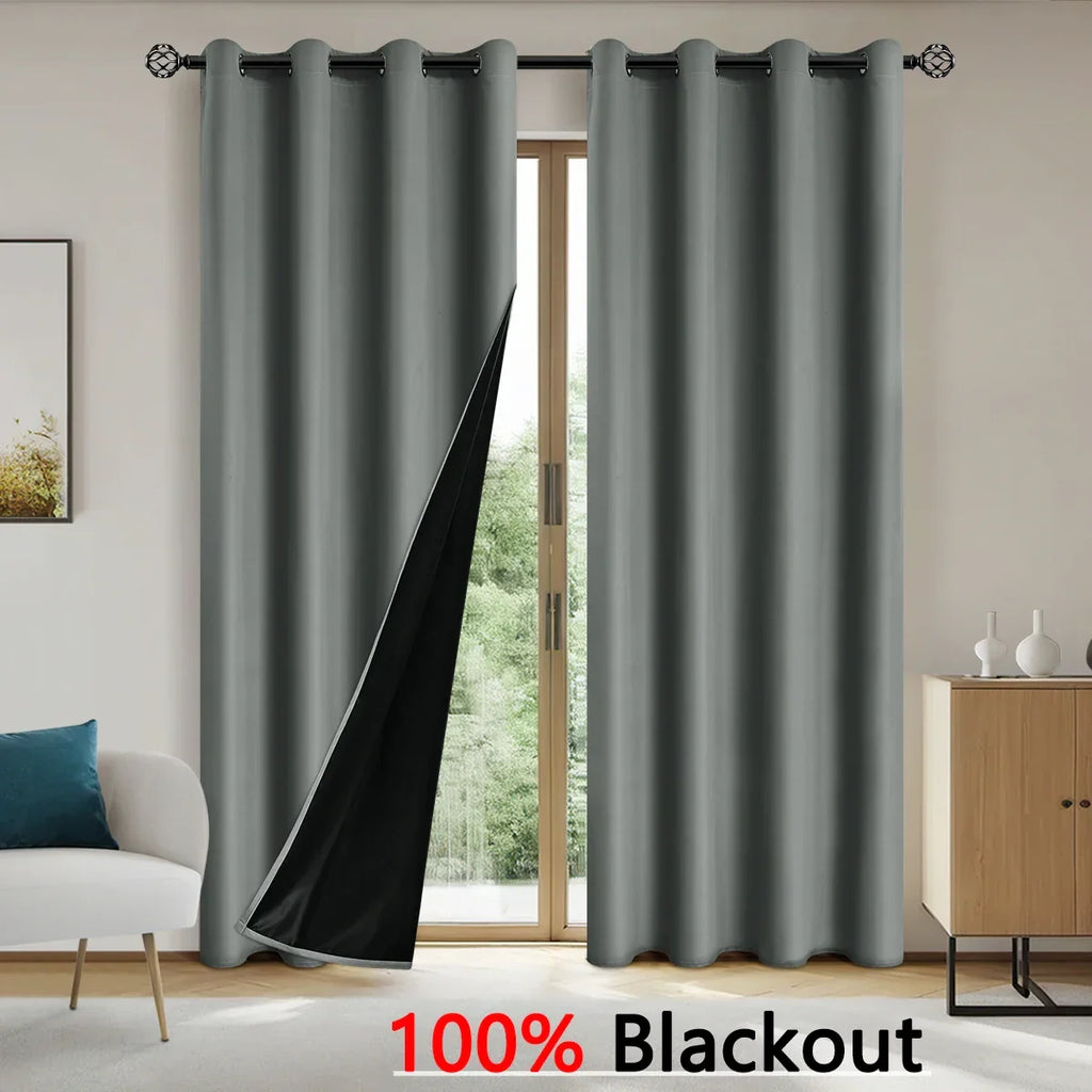 Grey 100% blackout curtains hanging on a decorative rod in a modern living room with sliding glass doors